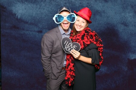 Couple using props to have a fun photo booth print at a wedding