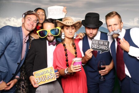 Group using props while doing fun poses at a photo booth